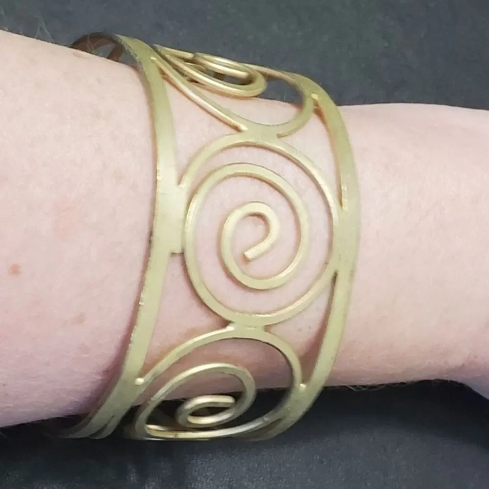 Gold tone swirly bangle cuff bracelet